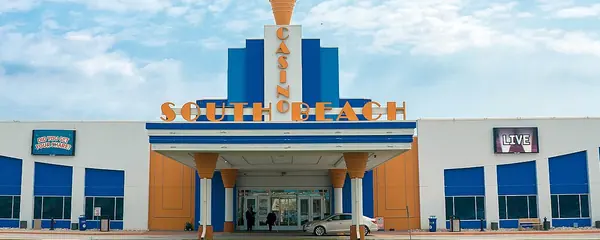 Front of South Beach Casino and Resort with its blue-and-orange facade and the hotel wing on the right